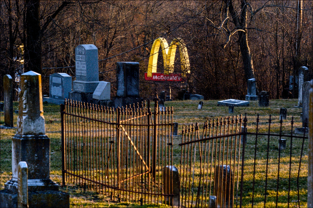 golden arches seen through cemetary